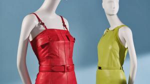Two mannequins, one with red leather dress and the other with a green leather dress
