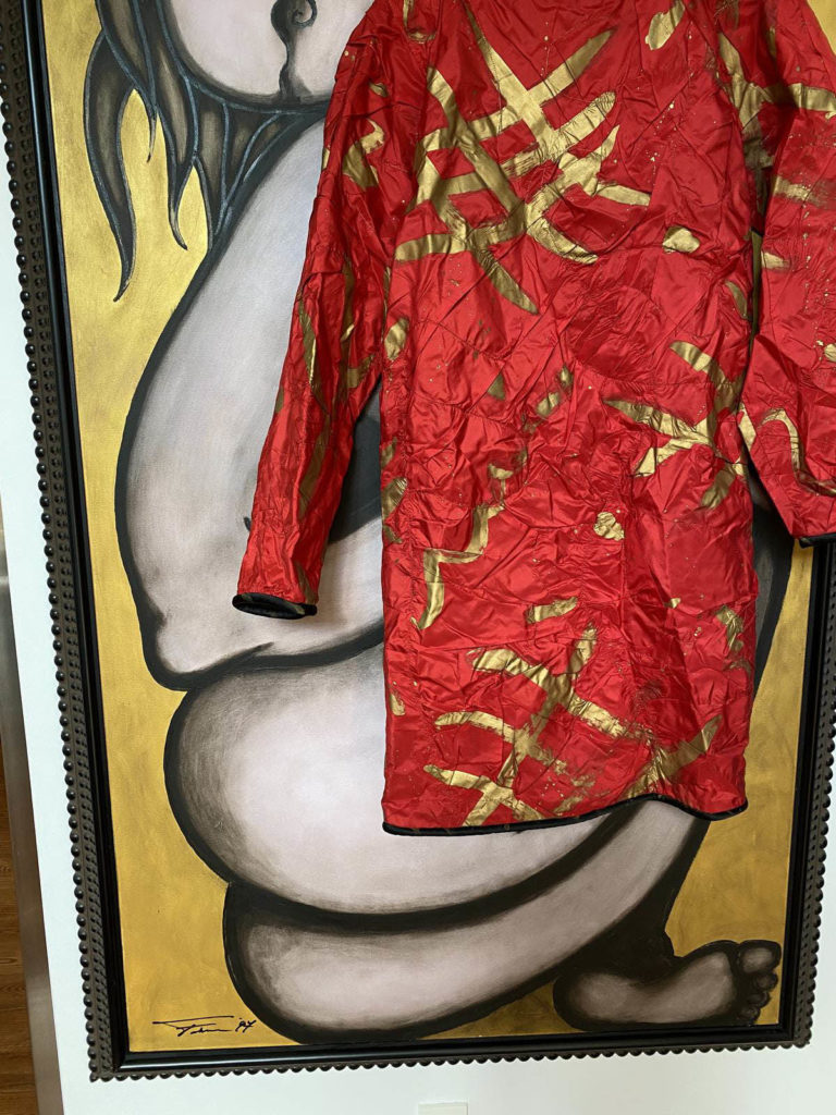 Hand-painted garment in front of a painting by Simon, image courtesy of Brigitte Steibel